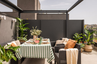 Ejemplo de terraza mediterránea de tamaño medio en azotea con pérgola, barandilla de vidrio y jardín de macetas