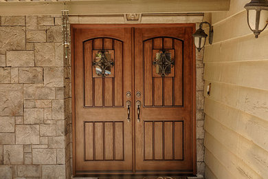 Design ideas for an expansive country front door in Orange County with brown walls, a double front door and a medium wood front door.