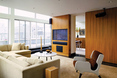 This is an example of a large contemporary living room in New York with a built-in media wall.