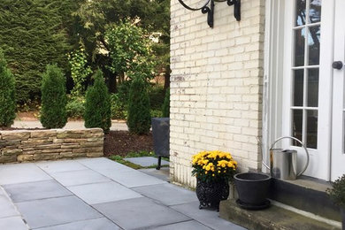 Patio - mid-sized contemporary courtyard stone patio idea in Other