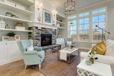 Example of a mid-sized transitional open concept light wood floor living room design in Boise with blue walls, a standard fireplace and a stone fireplace