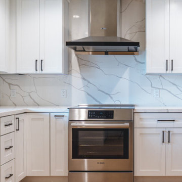 Modern White Shaker Kitchen with Navy Blue Island and Waterfall Quartz Counterto