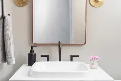 Example of a small minimalist powder room design in Chicago with a drop-in sink, flat-panel cabinets, medium tone wood cabinets, quartz countertops, a one-piece toilet and gray walls