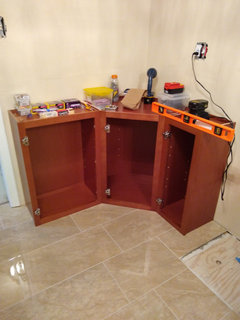 Attaching face frame of diagonal corner cabinet to straight cabinet ...