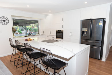 This is an example of a modern kitchen in Gold Coast - Tweed with shaker cabinets, white cabinets and quartz benchtops.
