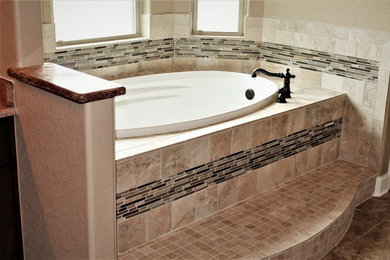Inspiration for a large timeless master beige tile and ceramic tile porcelain tile and beige floor drop-in bathtub remodel in Other with granite countertops and beige walls