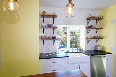 Kitchen - mid-sized modern slate floor and black floor kitchen idea in Other with a drop-in sink, flat-panel cabinets, white cabinets, stainless steel appliances and an island