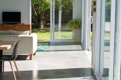 Inspiration for an expansive contemporary open concept family room in Auckland with concrete floors.