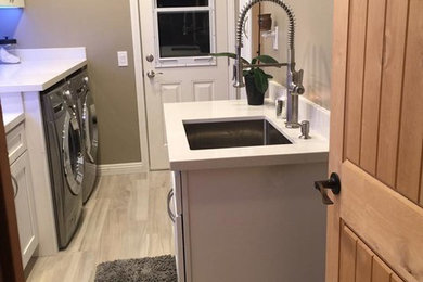 Mid-sized trendy single-wall porcelain tile and beige floor dedicated laundry room photo in San Diego with an undermount sink, recessed-panel cabinets, white cabinets, beige walls, a side-by-side washer/dryer and beige countertops