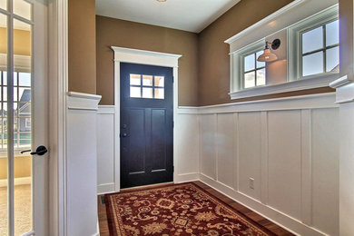 Arts and crafts medium tone wood floor entryway photo in Chicago with brown walls and a dark wood front door