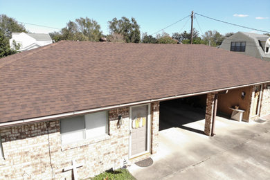Inspiration for a timeless one-story duplex exterior remodel in Austin with a hip roof, a shingle roof and a brown roof