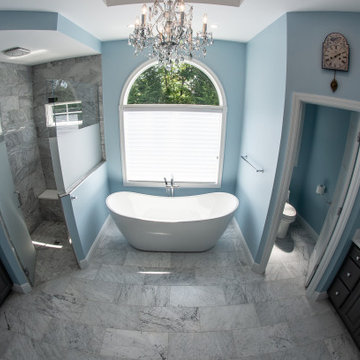 Traditional master bath utilizing frosted and clear glass to allow for needed pr