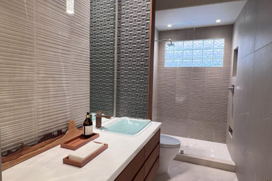 Mid-sized mid-century modern beige tile limestone floor, beige floor and single-sink doorless shower photo in Phoenix with flat-panel cabinets, a one-piece toilet, beige walls, a vessel sink, marble countertops, white countertops and a floating vanity