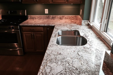 Open concept kitchen - mid-sized traditional l-shaped dark wood floor open concept kitchen idea in DC Metro with a double-bowl sink, raised-panel cabinets, dark wood cabinets, granite countertops, stainless steel appliances and an island