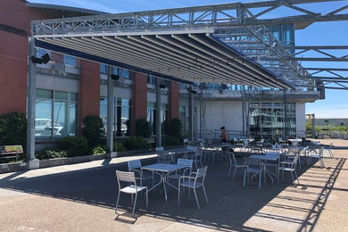 Huge courtyard patio photo in Burlington with an awning