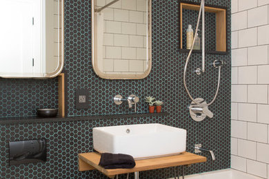 Inspiration for a small transitional master black tile and glass tile mosaic tile floor drop-in bathtub remodel in New York with a wall-mount toilet, black walls and a vessel sink