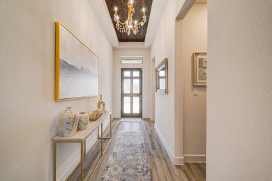 Large transitional medium tone wood floor, brown floor, wood ceiling and wall paneling entryway photo in Dallas with beige walls and a dark wood front door