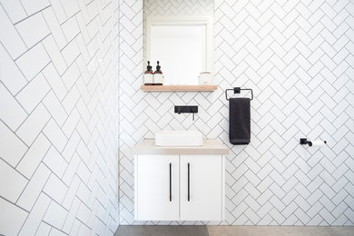 This is an example of a contemporary bathroom in Geelong with flat-panel cabinets, white cabinets, white tile, ceramic tile, ceramic floors, engineered quartz benchtops, grey floor and beige benchtops.