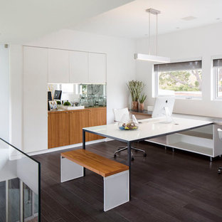 Photo of a modern home office and library in San Diego with bamboo flooring and a built-in desk.