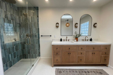 Mid-sized minimalist blue tile and terra-cotta tile ceramic tile, beige floor and double-sink bathroom photo in Other with brown cabinets, white walls, an integrated sink, marble countertops, a hinged shower door, white countertops and a built-in vanity