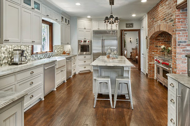 Design ideas for a large traditional kitchen in Dallas with beaded inset cabinets, stainless steel appliances, medium hardwood floors, with island and brown floor.