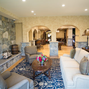 Foto de salón abierto, mediterráneo, grande, con paredes beige, moqueta, chimenea tradicional, marco de chimenea de piedra y suelo azul