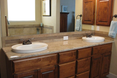 Inspiration for a mid-sized timeless master beige tile and ceramic tile porcelain tile bathroom remodel in Other with a drop-in sink, raised-panel cabinets, medium tone wood cabinets, granite countertops and beige walls
