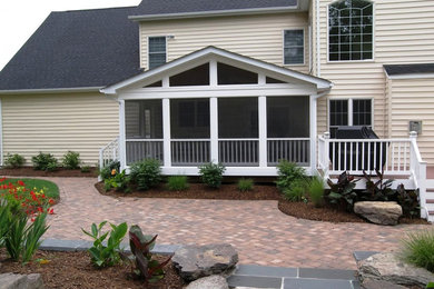Elegant screened-in back porch photo in Baltimore with decking and a roof extension