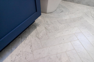 Bathroom - small transitional white tile and porcelain tile marble floor and white floor bathroom idea in New York with shaker cabinets, blue cabinets, a one-piece toilet, white walls, an undermount sink, marble countertops and white countertops