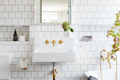 Design ideas for a traditional 3/4 bathroom in Melbourne with a claw-foot tub, a two-piece toilet, white tile, a wall-mount sink and black floor.