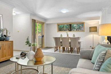 This is an example of a large contemporary open plan dining room in Sydney with carpet and grey floors.