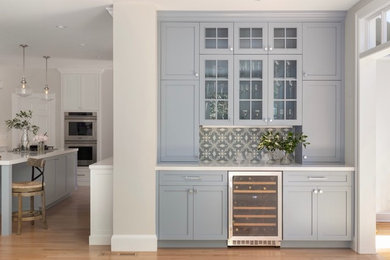 Mid-sized transitional l-shaped light wood floor and beige floor open concept kitchen photo in San Francisco with an undermount sink, shaker cabinets, blue cabinets, quartz countertops, blue backsplash, cement tile backsplash, stainless steel appliances, an island and white countertops