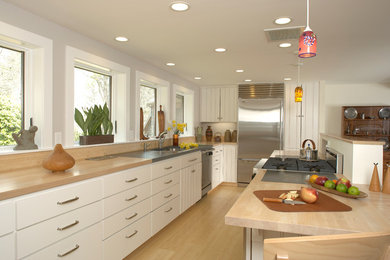 Trendy kitchen photo in San Francisco with white cabinets, wood countertops and stainless steel appliances