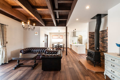 Imagen de salón abierto con suelo de madera oscura, estufa de leña, marco de chimenea de ladrillo y suelo marrón