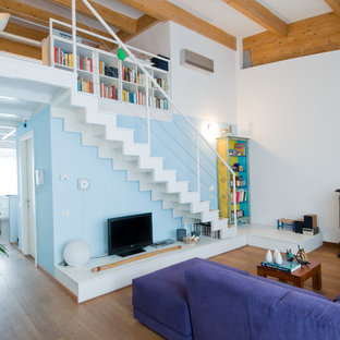 Idéer för att renovera ett mellanstort funkis allrum med öppen planlösning, med mellanmörkt trägolv, en öppen vedspis, en spiselkrans i metall, vita väggar och ett finrum