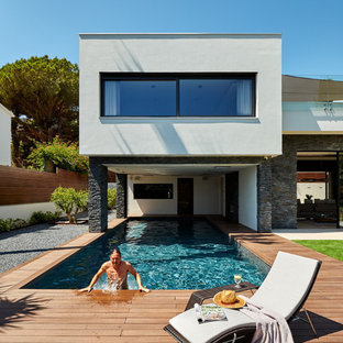 Idéer för en stor modern träningspool framför huset, med poolhus och trädäck