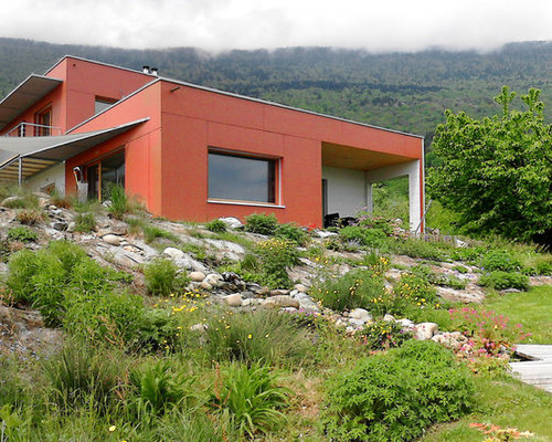 Réalisation d'une façade de maison rouge design de taille moyenne et à un étage avec un toit plat.