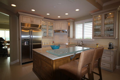 Example of a classic eat-in kitchen design in Miami with a double-bowl sink, flat-panel cabinets, distressed cabinets, quartzite countertops, beige backsplash, subway tile backsplash, stainless steel appliances and an island