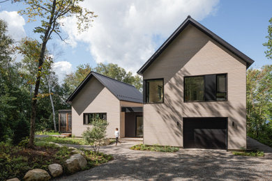 Inspiration for a large contemporary gray two-story wood and clapboard exterior home remodel in Montreal with a metal roof and a black roof