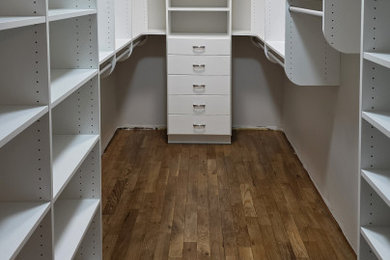 Mid-sized transitional gender-neutral dark wood floor and brown floor walk-in closet photo in Cleveland with flat-panel cabinets and white cabinets