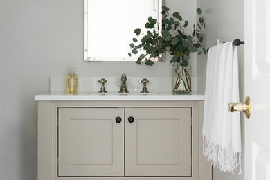 Example of a mid-sized eclectic white tile and subway tile cement tile floor and black floor bathroom design in Boston with shaker cabinets, gray cabinets, a two-piece toilet, white walls, a drop-in sink and marble countertops