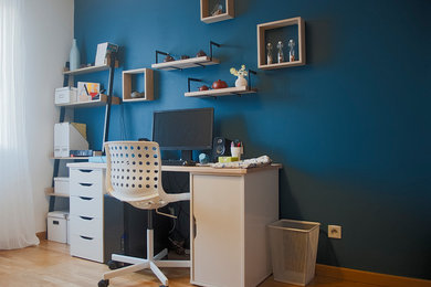 This is an example of a contemporary home office in Other with blue walls and light hardwood floors.