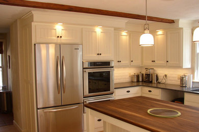 Inspiration for a mid-sized timeless l-shaped light wood floor eat-in kitchen remodel in Boston with an undermount sink, shaker cabinets, white cabinets, granite countertops, stainless steel appliances, an island, white backsplash and subway tile backsplash