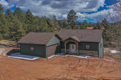 Mid-sized modern green two-story brick house exterior idea in Other with a butterfly roof, a shingle roof and a brown roof