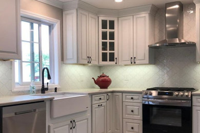 Eat-in kitchen - transitional porcelain tile eat-in kitchen idea in New York with a farmhouse sink, raised-panel cabinets, turquoise cabinets, quartz countertops, white backsplash, ceramic backsplash, stainless steel appliances and white countertops