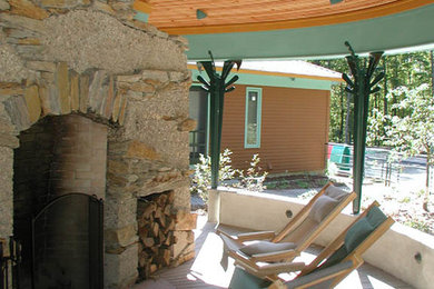 This is an example of a large transitional side porch design in Burlington with a fire pit, decking and a roof extension.