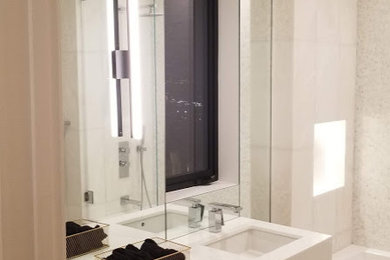 Example of a mid-sized minimalist master white tile and marble tile marble floor, brown floor and single-sink bathroom design in Phoenix with flat-panel cabinets, light wood cabinets, a wall-mount toilet, white walls, an undermount sink, quartz countertops, a hinged shower door, white countertops and a floating vanity