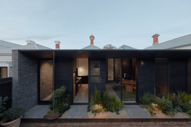 Ejemplo de fachada de casa negra y gris actual pequeña de una planta con revestimiento de madera, tejado plano y tejado de metal