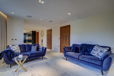 This is an example of a large traditional enclosed living room in Essex with white walls, marble flooring and white floors.