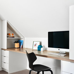 Photo of a contemporary home office in Sydney with white walls, carpet, a built-in desk and brown floor.